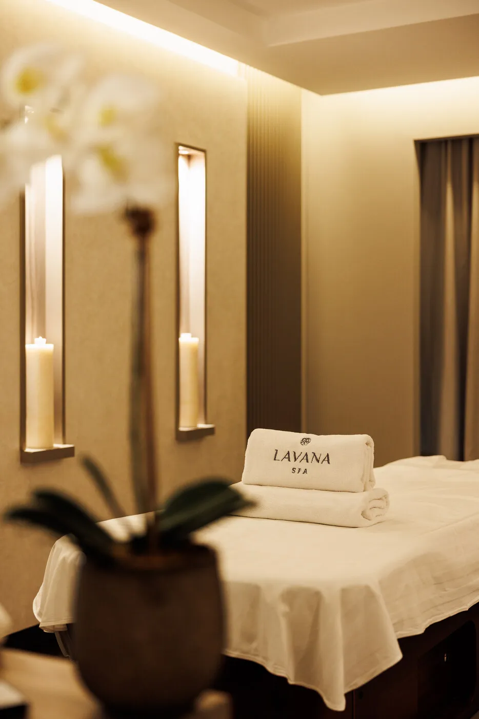 Massage room at Lavana Spa DIFC, with a single table and wall lights