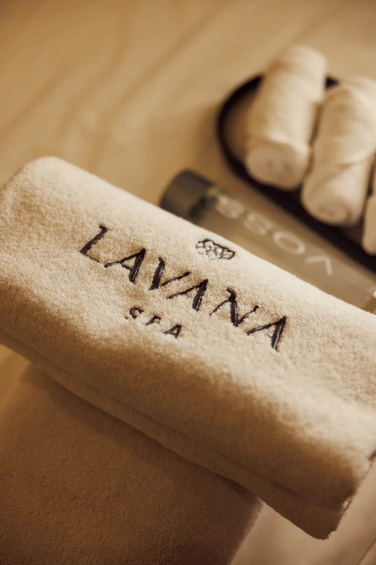 Embroidered Lavana Spa towel with rolled hand towels and a bottle of water, prepared for a private jacuzzi session at the DIFC branch